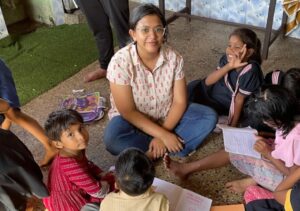 Maria Saju sits among the children from our shelter, providing companionship and support. Her presence embodies warmth and care, fostering a sense of community and belonging. Image for Maria's blog update on our website.