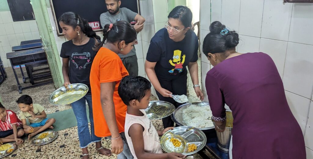 Maria Saju, our dedicated intern, serving nutritious meals to children at our shelter. Her compassionate service ensures that every child receives the nourishment they need. Image for Maria's blog update on our website.